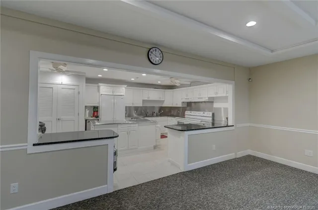 a kitchen with white cabinets and sink