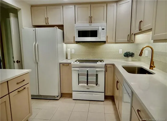 a kitchen with appliances a sink and cabinets
