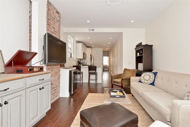 215 Adams Street, Unit 2L Hoboken, NJ 07030 - Photo 4 of 12 a living room with furniture a flat screen tv and kitchen view