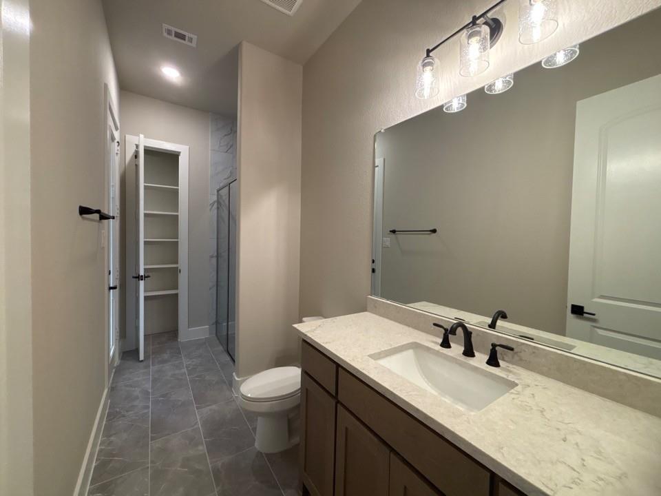 912 Creekview Whites Road Van Alstyne, TX 75495 - Photo 12 of 13 Modern vanity with an integrated sink, light-toned countertop, and matte black fixtures