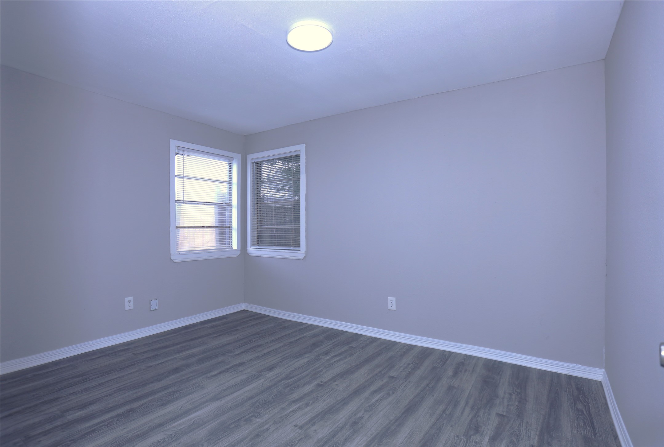 123 West 6th Street, Unit 2 Freeport, TX 77541 - Photo 4 of 8 an empty room with wooden floor and windows