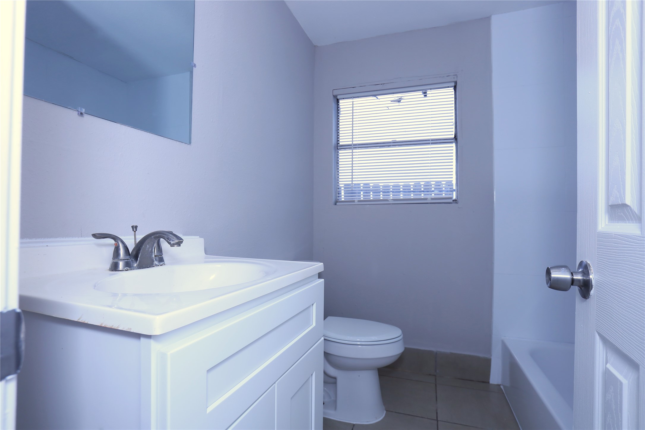 123 West 6th Street, Unit 2 Freeport, TX 77541 - Photo 7 of 8 a bathroom with a toilet sink and mirror