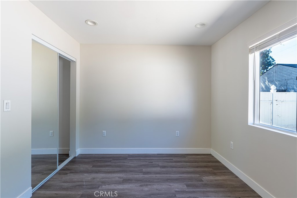 7022 Crebs Avenue Reseda, CA 91335 - Photo 13 of 20 a view of an empty room with wooden floor and a window