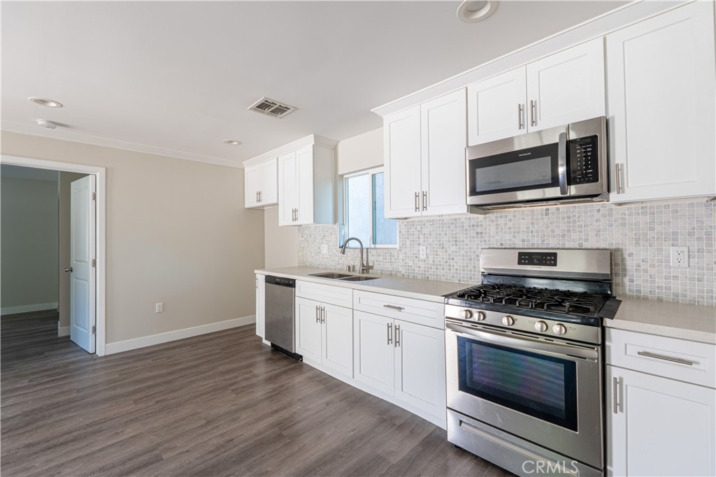 7022 Crebs Avenue Reseda, CA 91335 - Photo 10 of 20 a kitchen with stainless steel appliances white cabinets and a stove top oven