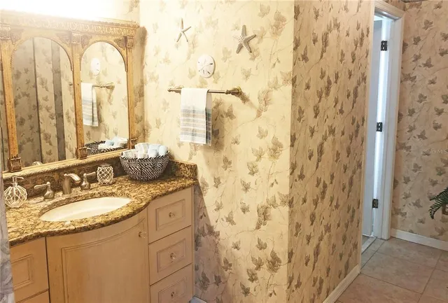 a bathroom with a granite countertop sink a mirror and a shower