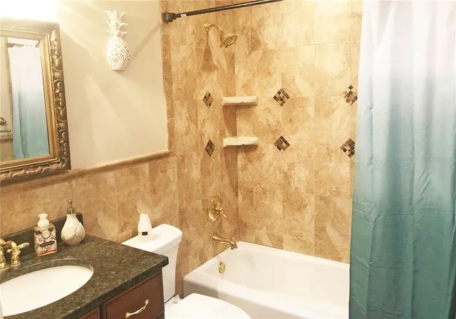 a bathroom with a granite countertop sink and a mirror a bathtub