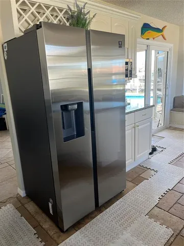 a kitchen with stainless steel appliances kitchen island a refrigerator and a sink
