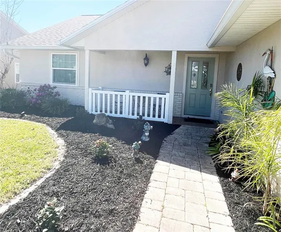 a view of a porch with a chair and potted plants