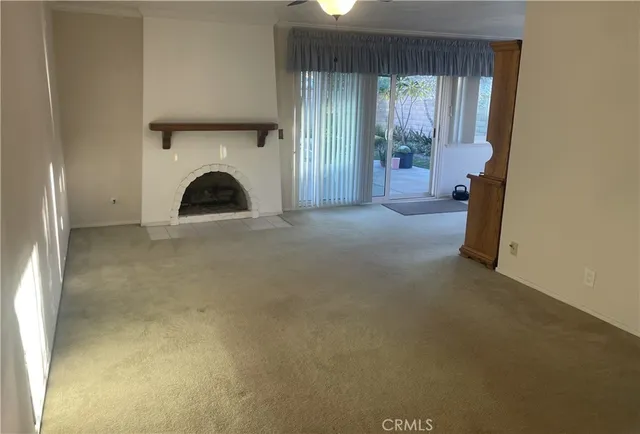 a view of empty room with windows and fireplace