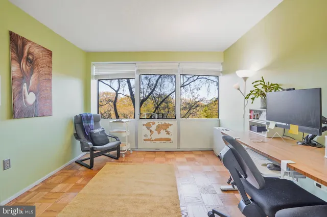 a view of a workspace with furniture and a window