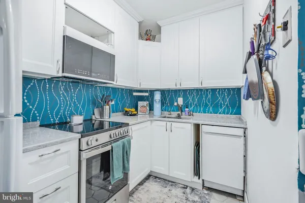 a kitchen with stainless steel appliances cabinets and wooden floor