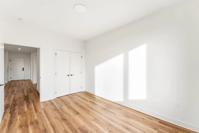a view of a bedroom with wooden floor and bathroom