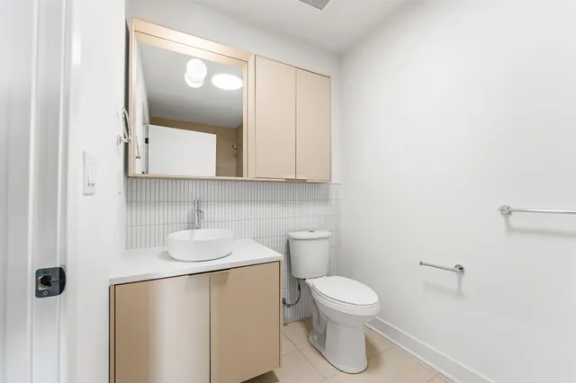 a bathroom with a toilet sink and mirror