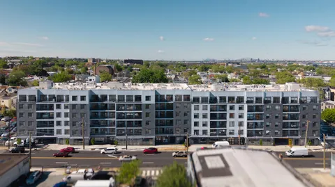 a front view of a building with cars parked