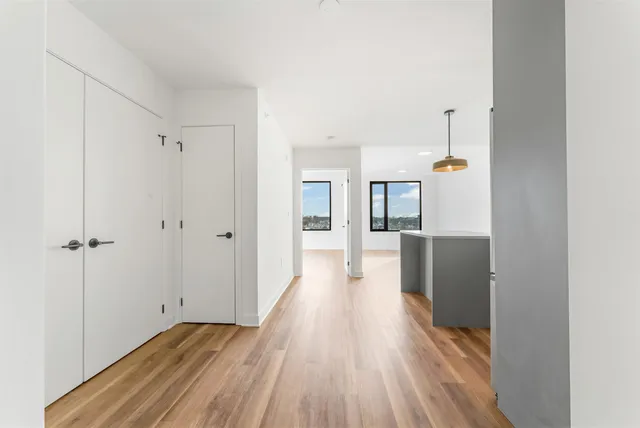 a view of a hallway with wooden floor and closet