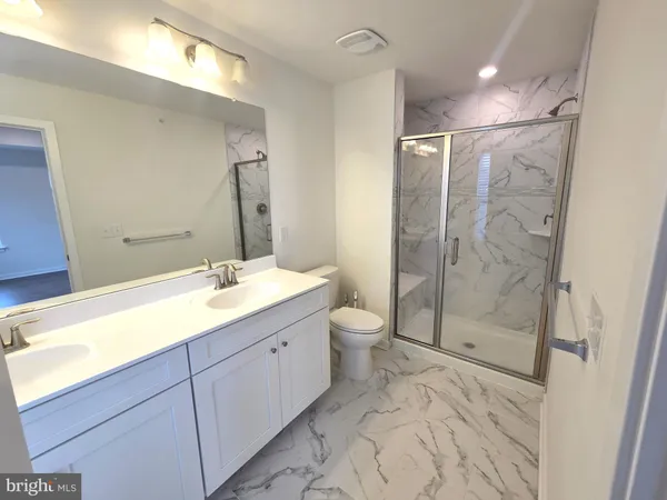 a bathroom with a double vanity sink toilet and shower