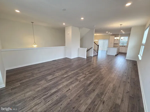 a view of a living room a kitchen with a wooden floor