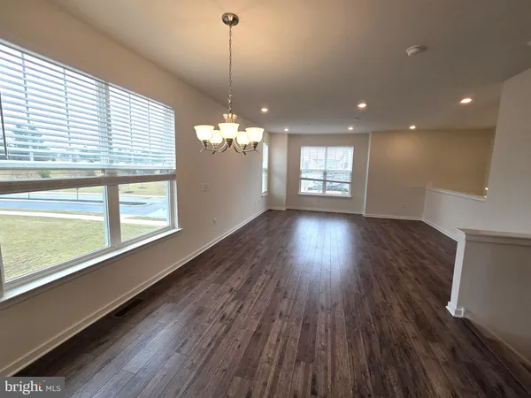 a view of a room with wooden floors and chandelier