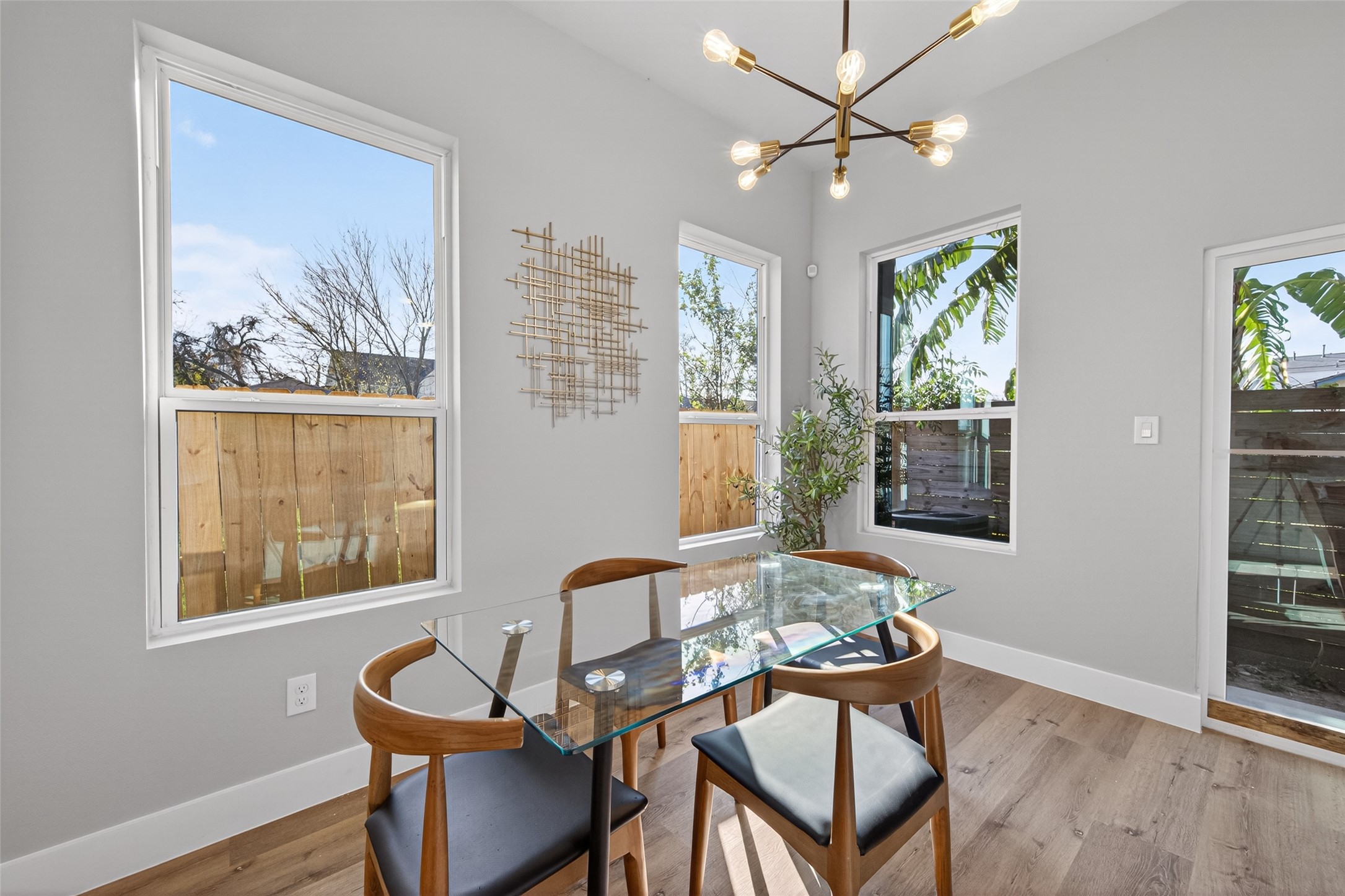 4115 Yale Street Houston, TX 77018 - Photo 20 of 37 Dining area framed by large windows, statement modern chandelier, and clean architectural lines—perfect for intimate dinners or hosting guests in style.