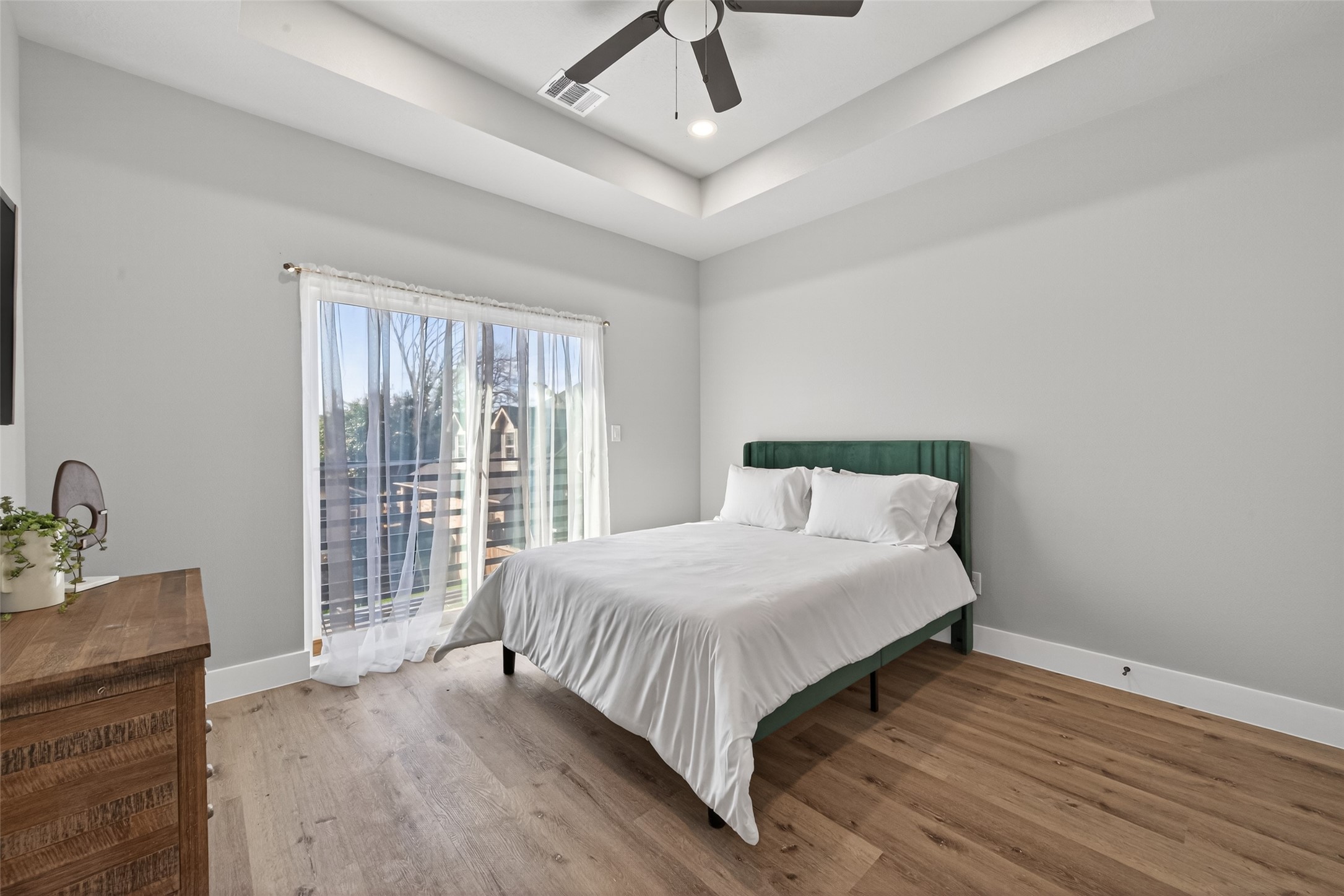 4115 Yale Street Houston, TX 77018 - Photo 32 of 37 Alternate primary suite view highlighting the generous room scale, crisp designer paint palette, and seamless white oak–tone plank flooring—creating a calm, sophisticated atmosphere ideal for rest and relaxation.