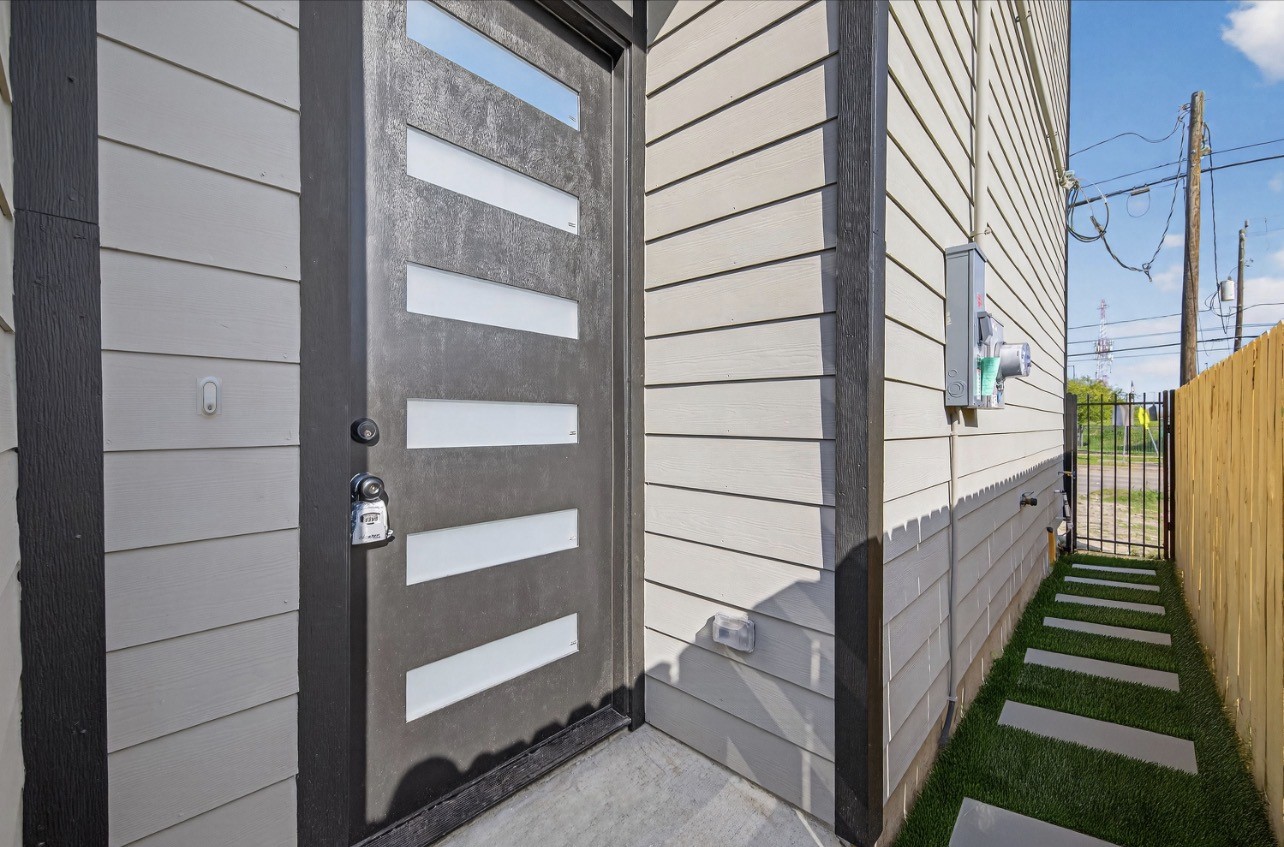 4115 Yale Street Houston, TX 77018 - Photo 5 of 37 Modern entry experience with a statement 8' front door featuring frosted glass inlays, contemporary hardware, and clean-lined siding, offering privacy while allowing natural light to filter inside.