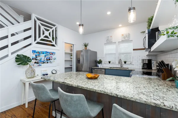 a kitchen with stainless steel appliances granite countertop a sink stove and refrigerator