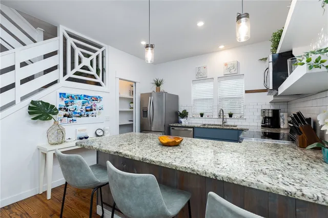 a kitchen with stainless steel appliances granite countertop a sink stove and refrigerator