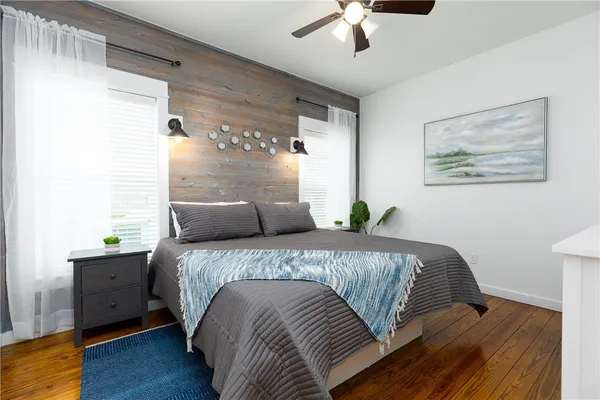 a bed sitting in a bedroom next to a window with a chandelier