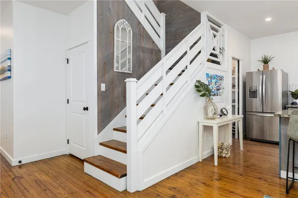 a view of a hallway with wooden floor and staircase