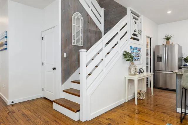 a view of a hallway with wooden floor and staircase