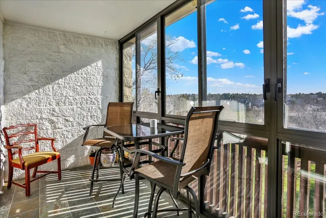 a view of a balcony with chairs and wooden floor