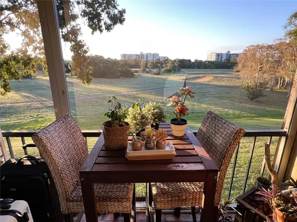 a view of a chairs and table on the terrace near a lake view