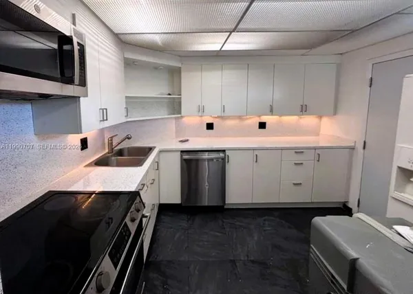 a kitchen with a sink a stove and cabinets