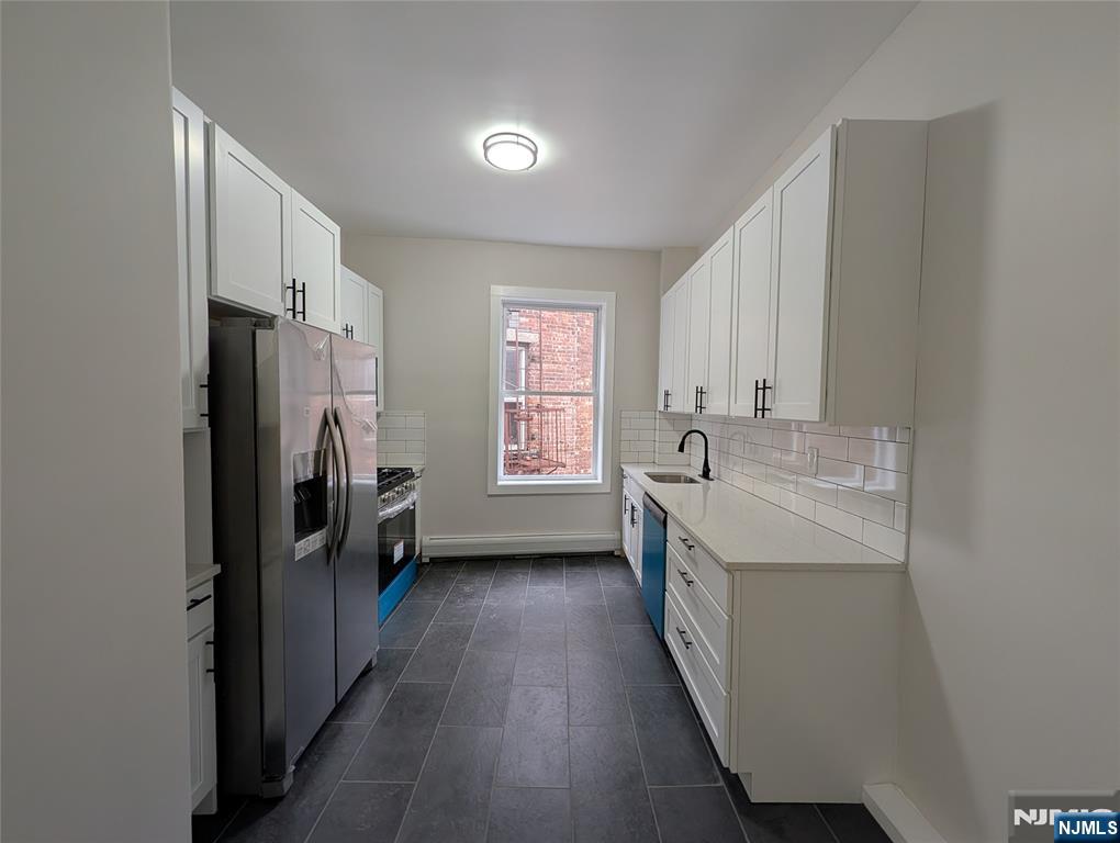 a kitchen with a sink a counter top space stainless steel appliances and a window