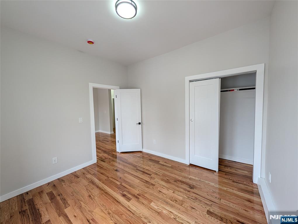 69 Howe Avenue, Unit 9 Passaic, NJ 07055 - Photo 14 of 20 a view of an empty room with wooden floor and closet
