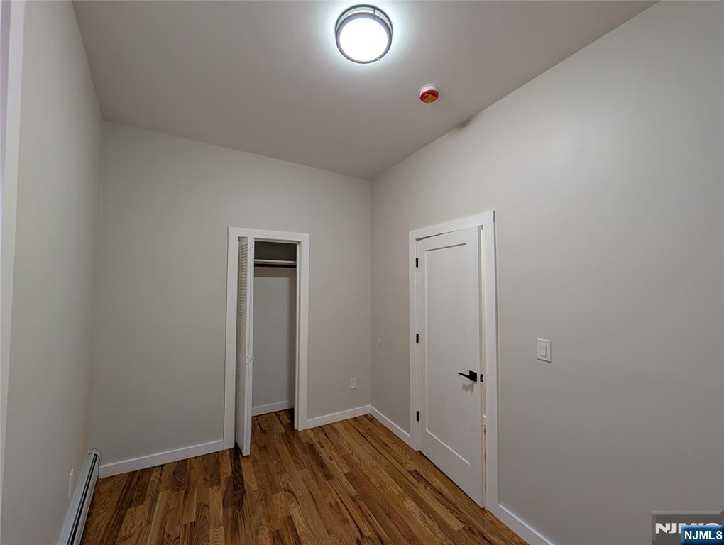 69 Howe Avenue, Unit 9 Passaic, NJ 07055 - Photo 17 of 20 an empty room with wooden floor and closet