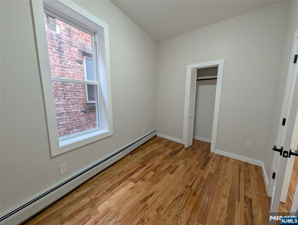 69 Howe Avenue, Unit 9 Passaic, NJ 07055 - Photo 18 of 20 a view of empty room with window and wooden floor