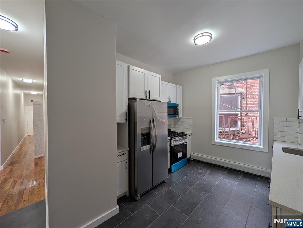 69 Howe Avenue, Unit 9 Passaic, NJ 07055 - Photo 2 of 20 a view of a kitchen with refrigerator and window