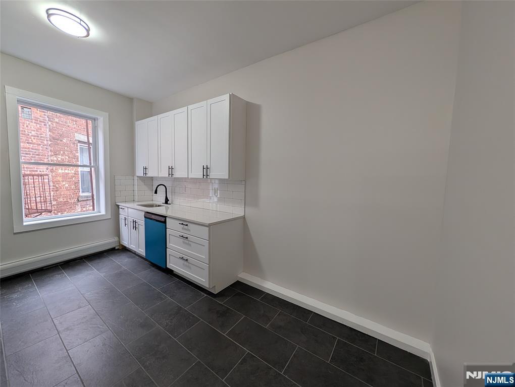 69 Howe Avenue, Unit 9 Passaic, NJ 07055 - Photo 3 of 20 a kitchen with a white cabinets and white appliances