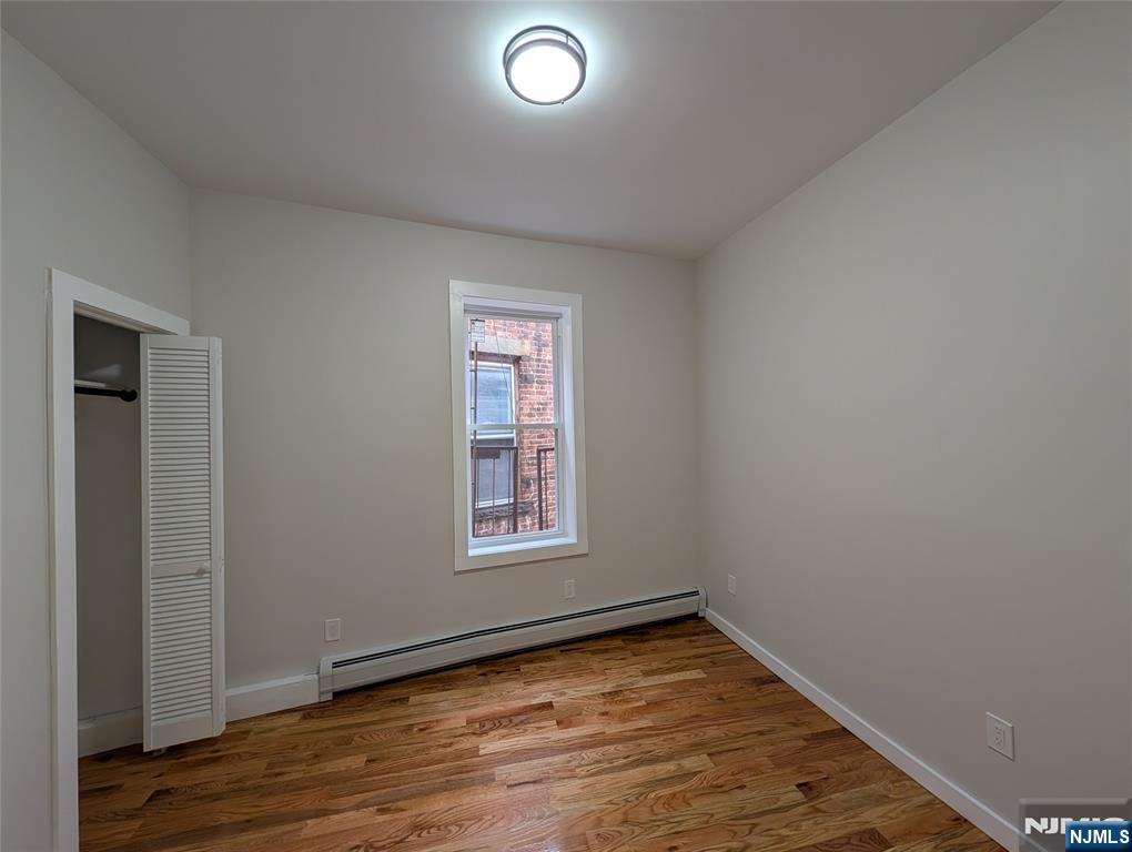 69 Howe Avenue, Unit 9 Passaic, NJ 07055 - Photo 7 of 20 an empty room with wooden floor and windows