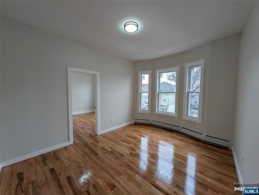 69 Howe Avenue, Unit 9 Passaic, NJ 07055 - Photo 10 of 20 a view of an empty room with wooden floor and a window