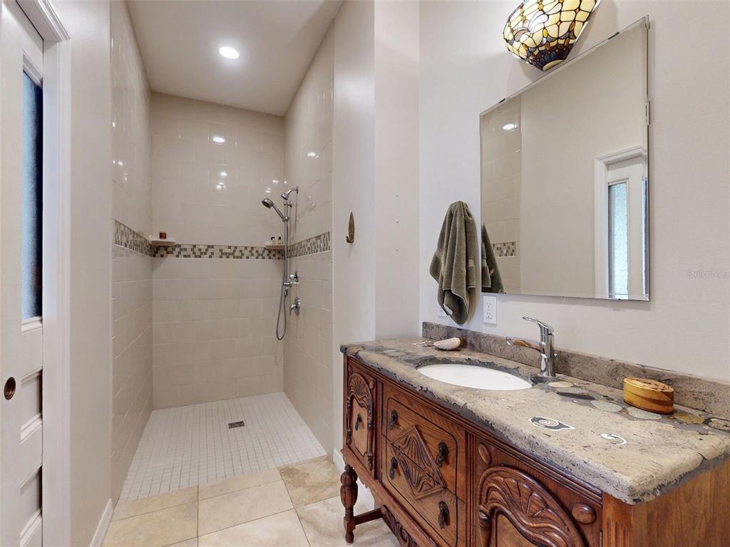 536 Faulkner Street New Smyrna Beach, FL 32168 - Photo 24 of 57 a bathroom with a granite countertop sink a large mirror and shower
