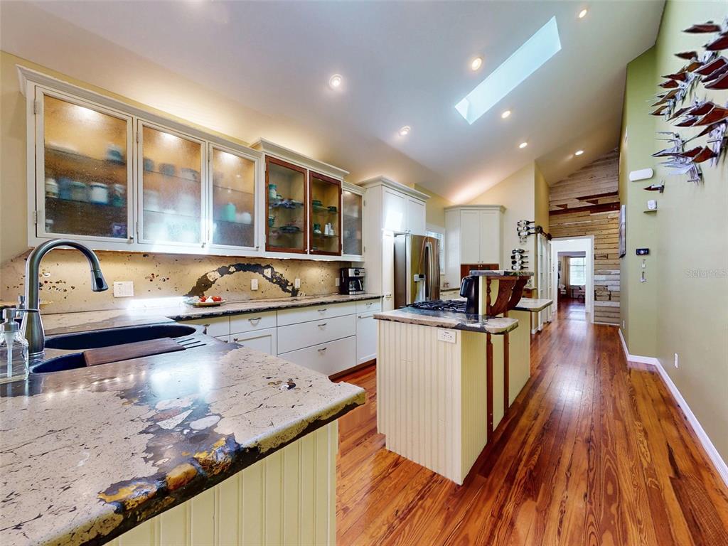 536 Faulkner Street New Smyrna Beach, FL 32168 - Photo 6 of 57 a large kitchen with stainless steel appliances granite countertop a lot of counter space and wooden floors