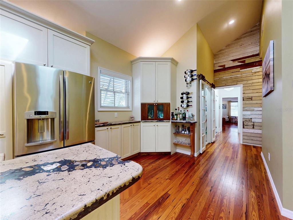 536 Faulkner Street New Smyrna Beach, FL 32168 - Photo 7 of 57 a kitchen with stainless steel appliances wooden floor and refrigerator