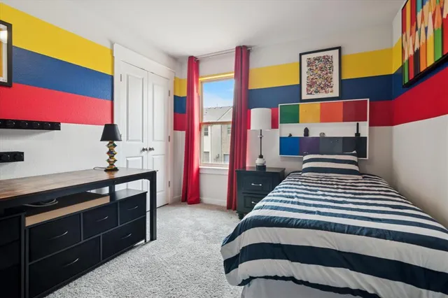 a bedroom with a bed and a dresser next to a window