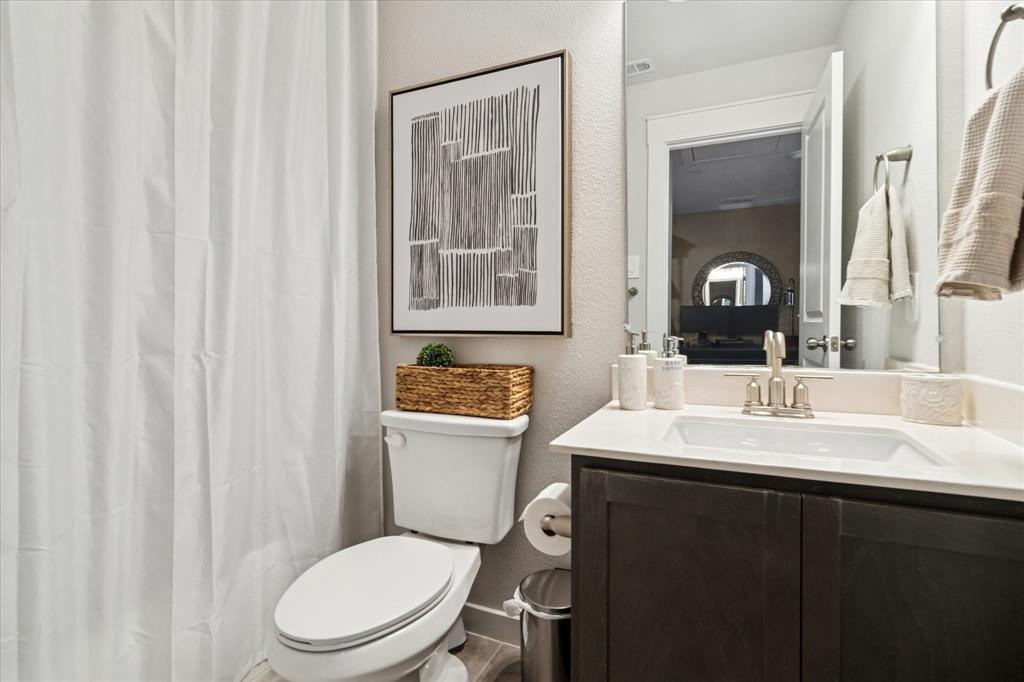 3047 Tenor Way Sachse, TX 75048 - Photo 15 of 17 a bathroom with a toilet a sink and a mirror