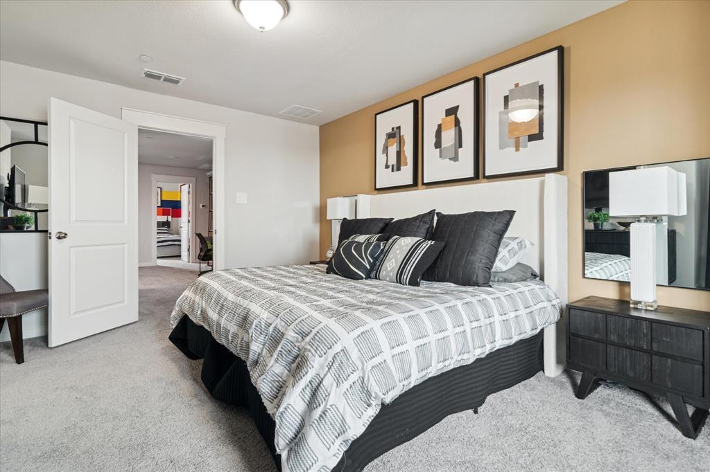 3047 Tenor Way Sachse, TX 75048 - Photo 10 of 17 a bedroom with a bed and a lamp on dresser