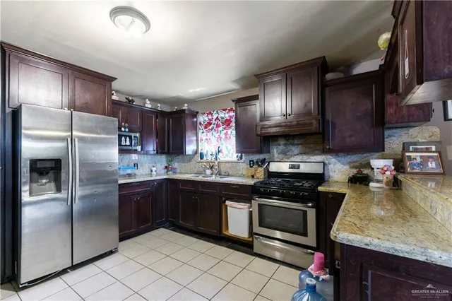 a kitchen with granite countertop stainless steel appliances and wooden cabinets