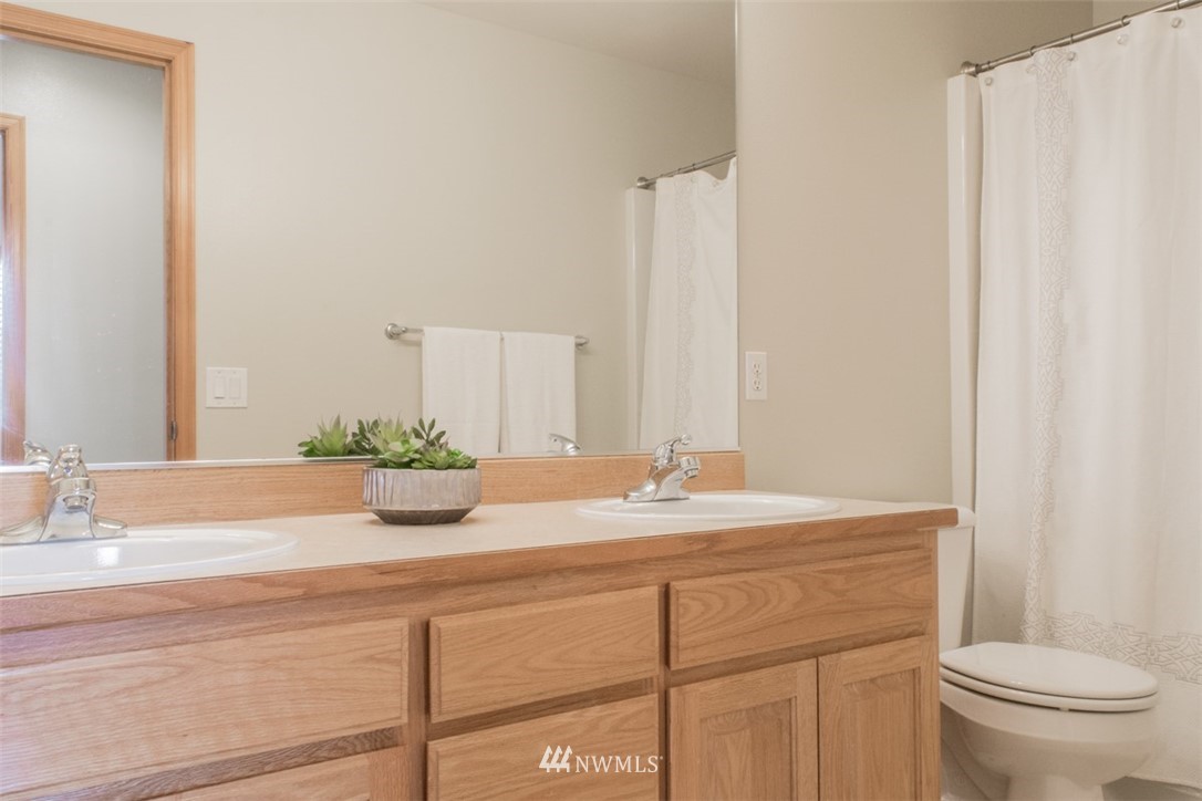 302 172nd Place Southeast Bothell, WA 98012 - Photo 17 of 20 a bathroom with a granite countertop sink a toilet and mirror