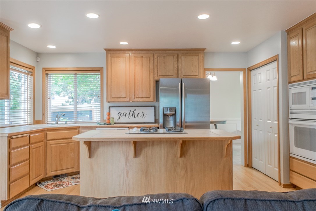 302 172nd Place Southeast Bothell, WA 98012 - Photo 6 of 20 a kitchen with stainless steel appliances granite countertop a sink a stove a refrigerator and island with wooden floor